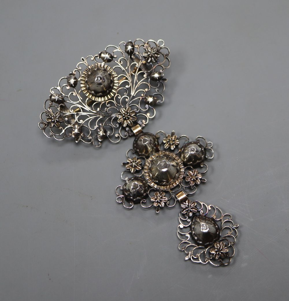 A continental pierced white and yellow metal, diamond set graduated three tier drop brooch, 79mm, gross 13.8 grams.